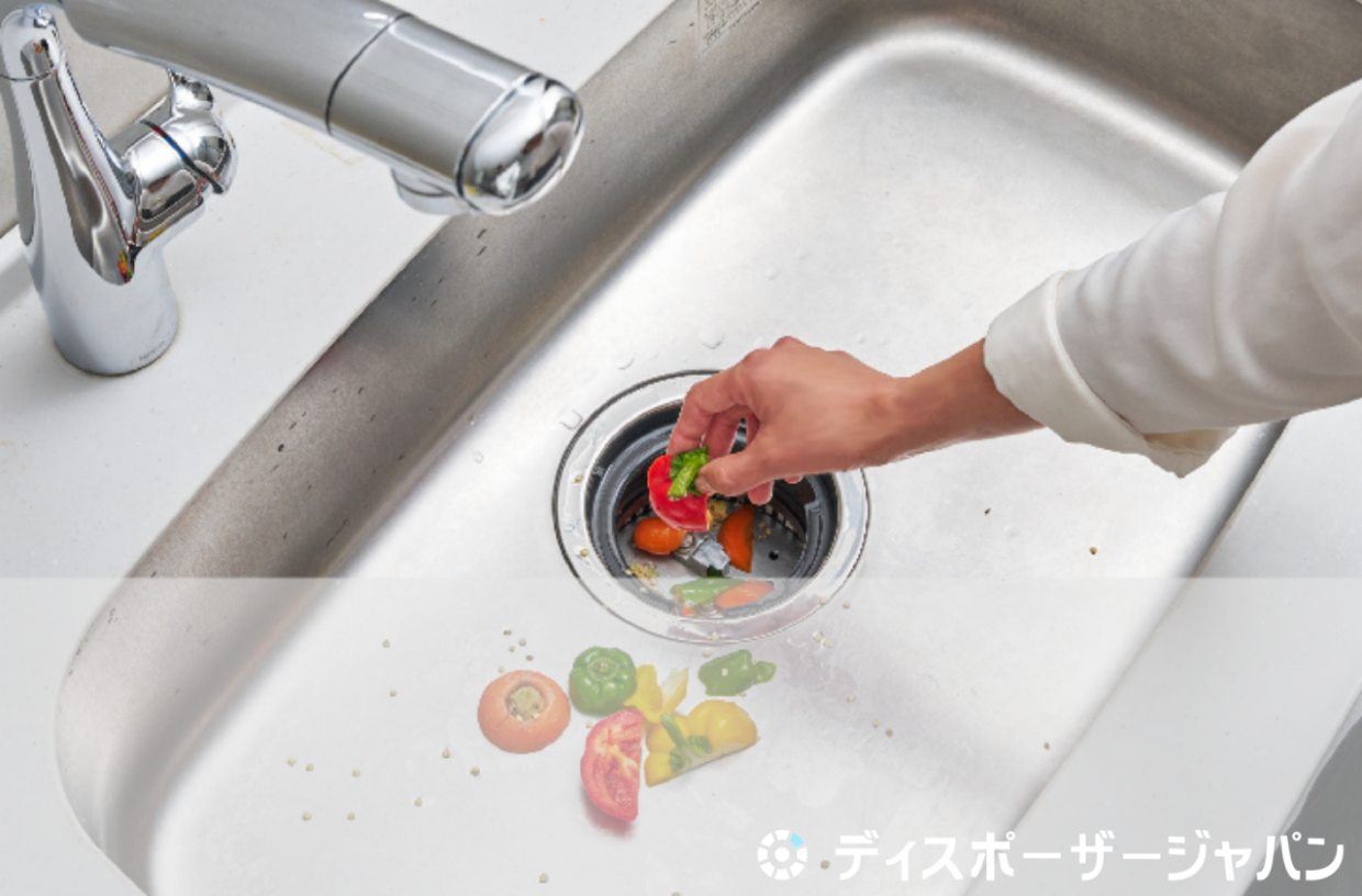 ゴミをディスポーザーに入れている画像
